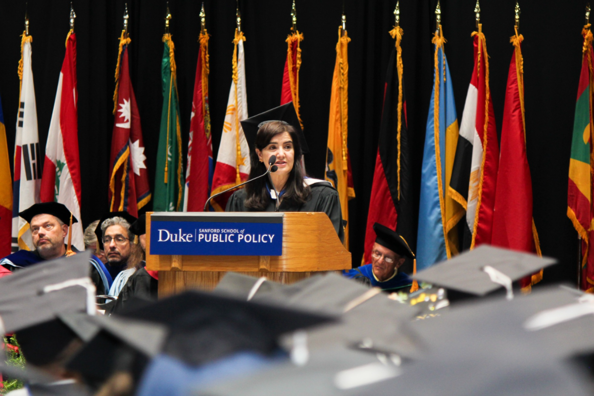 Noorin Nazari speaking at a lectern on stage for graduation