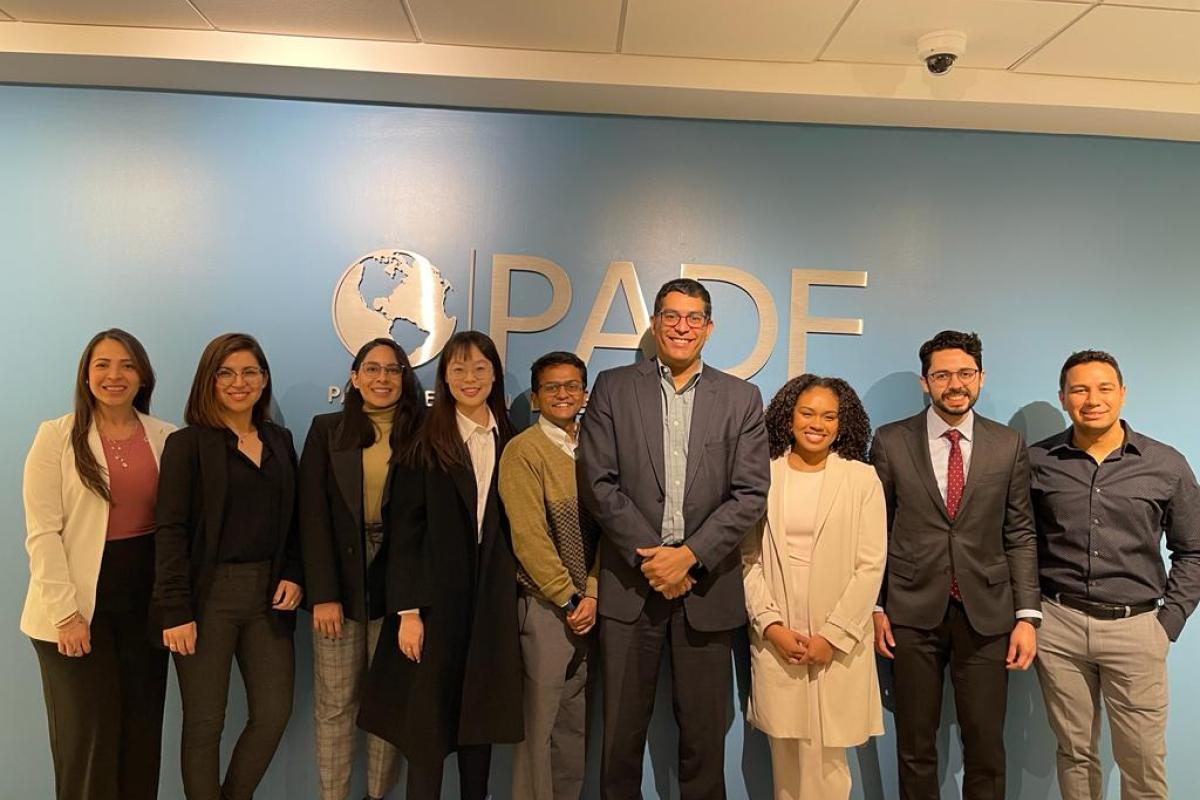 Nine people standing in front of a Pan-American Development Foundation sign.